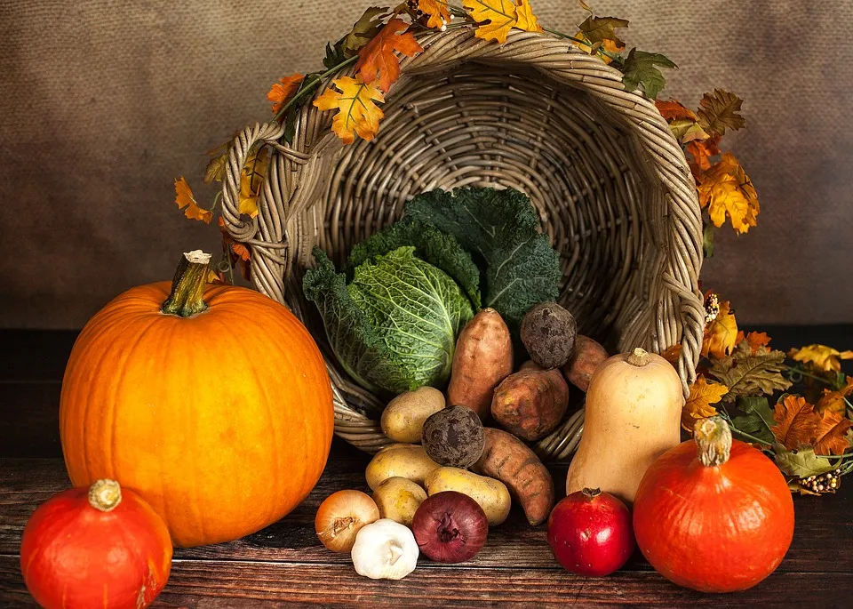 Umgestürzter Korb mit Kürbissen und Herbstgemüse